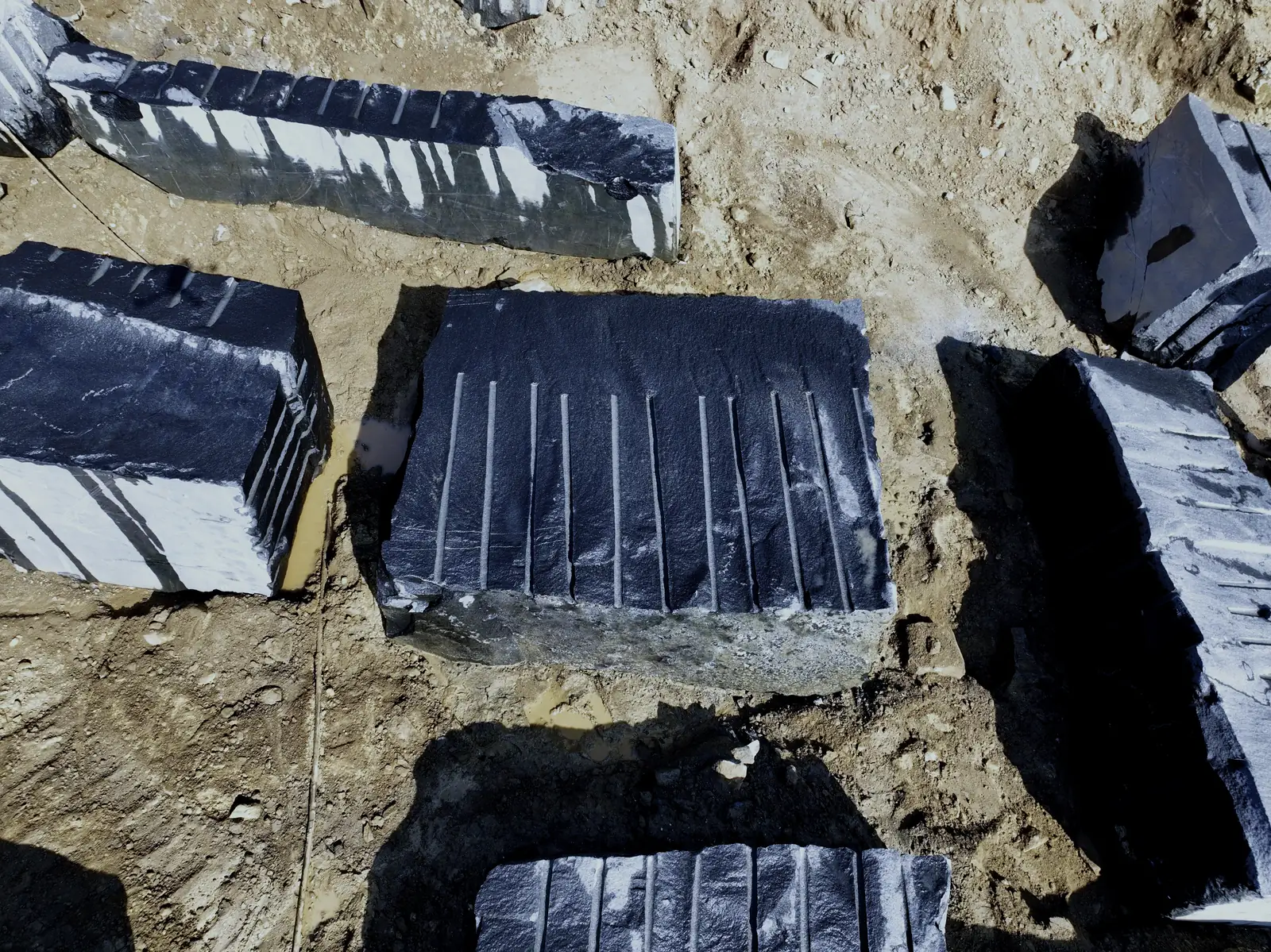 Squared granite blocks with drill-line faces on the quarry floor